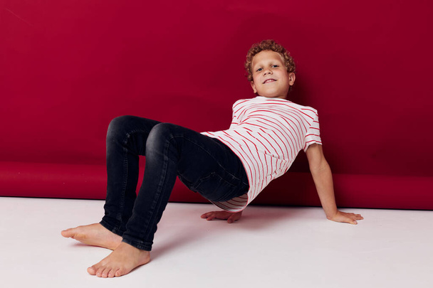 boy on the floor wearing a t-shirt posing Studio - Foto, imagen