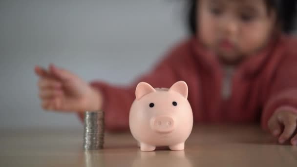 Perhe säästää rahaa. Aasialainen vauva tyttö tytär aikoo viettää tulevaisuutta tosissaan, rahoitus ja säästö, perhe ja taloudellinen käsite. - Materiaali, video