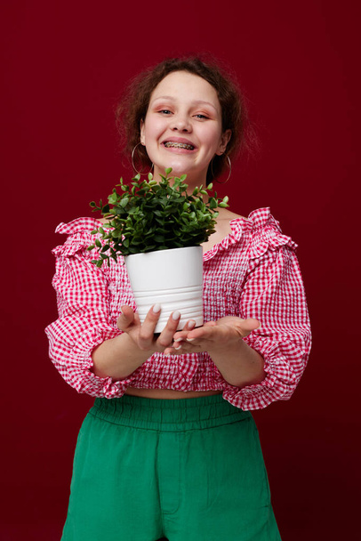 cheerful woman in pink blouse flower in a pot isolated background unaltered - Fotografie, Obrázek
