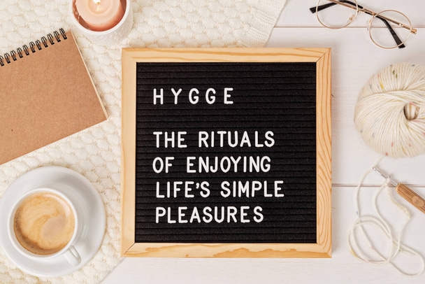 Letter board with text hygge the rituals of enjoying life simple pleasures. Comfort and cozy slow life concept. Flat lay, top view - Photo, Image