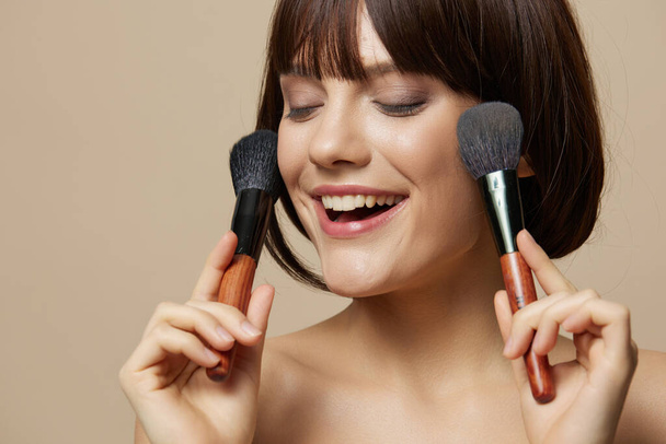 woman brushe cosmetics attractive look posing beige background - Foto, afbeelding