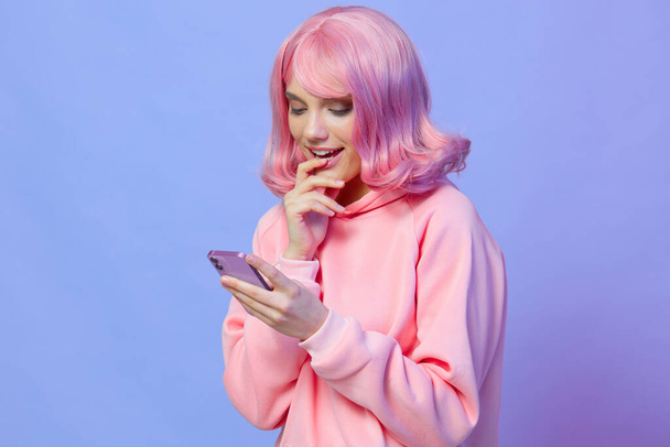 νεαρή γυναίκα κρατώντας ένα τηλέφωνο ποζάροντας τεχνολογία Lifestyle μόδας - Φωτογραφία, εικόνα