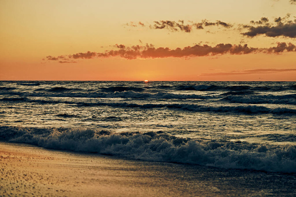 Bellissimo tramonto sulle onde del mare, mezzo sole sotto l'orizzonte, vista sul mare. Onde blu del mare in luce solare atmosferica nel cielo del tramonto, vacanze estive calde sul mare, paesaggi marini incredibili - Foto, immagini