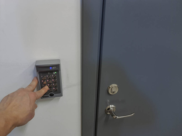 Κλείσιμο προβολής του χεριού σε ψηφιακή κλειδαριά κοντά στην πόρτα εισόδου. Έννοια ασφαλείας. Σουηδία.  - Φωτογραφία, εικόνα