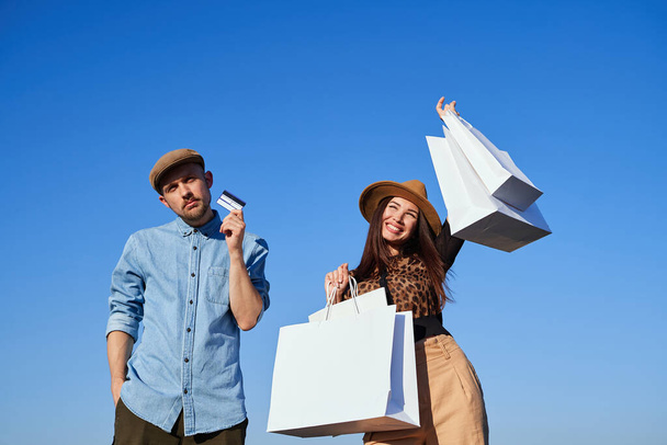 Tema de compras: pareja con tarjeta de crédito y bolsas de compras - Foto, imagen
