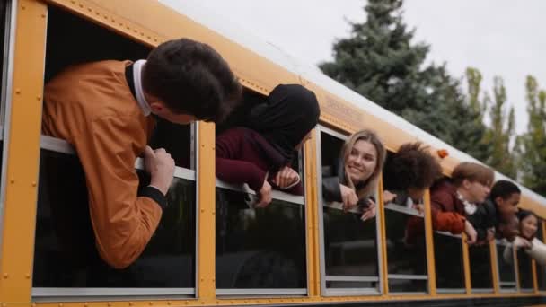 Χαρούμενοι έφηβοι με κεφάλια έξω από τα παράθυρα των σχολικών λεωφορείων - Πλάνα, βίντεο