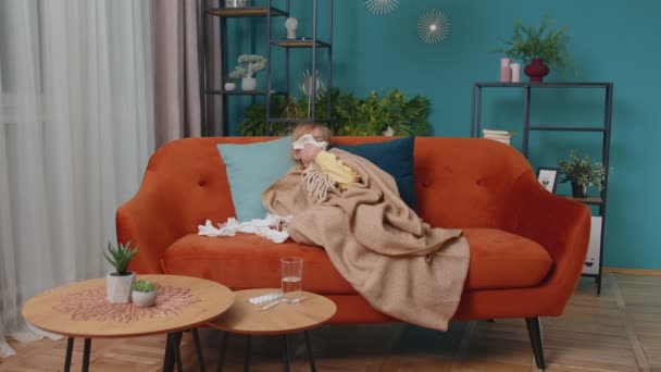 Děvčátko v kostkovaném, které trpí alergií na zimnici, vysmrká se doma do ubrousku - Záběry, video