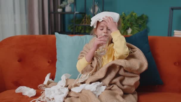 Enfant fille à carreaux souffrant de rhume ou d'allergie, boire de l'eau de la pilule de médecine à la maison - Séquence, vidéo