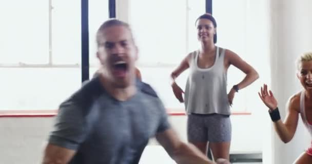 Getting the group all pumped up. 4k video of a group of people celebrating after a workout at the gym. - Séquence, vidéo