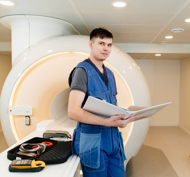 installer engineer of mri apparatus near scanner with instructions and tools - Photo, Image