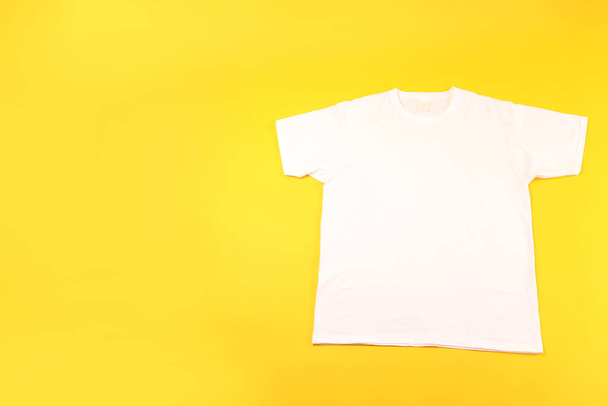 White t-shirt with space for print on yellow background - Foto, Bild