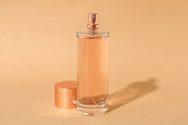 Bej arka planda boş bir parfüm şişesi - Fotoğraf, Görsel