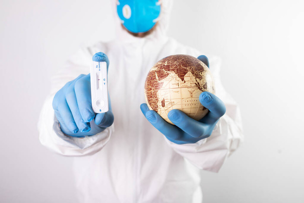 World epidemic danger concept. Hands of doctorholding planet Earth and negative coronavirus test. - Фото, зображення