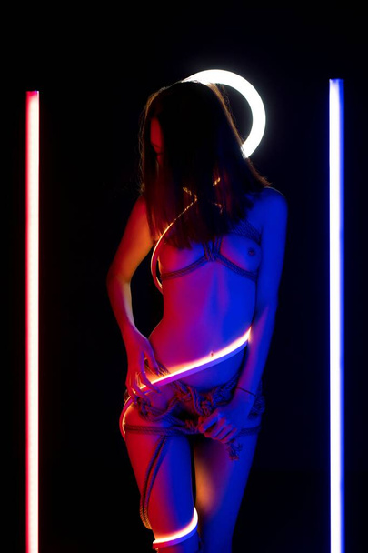 Seductive nude female in tight Japanese bondage in darkness - Photo, image