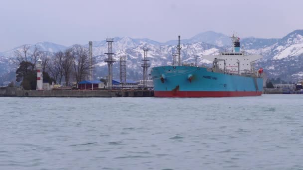 ferry stands in the port against the backdrop of snow-capped mountains. - Footage, Video