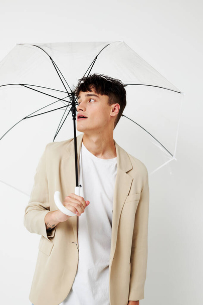 Photo young boyfriend holding an umbrella in the hands of posing fashion light background unaltered - Foto, immagini