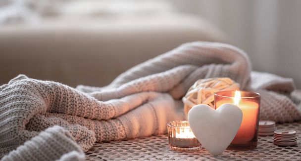 Уютный фон ко Дню Святого Валентина со свечой и декоративным сердцем. - Фото, изображение