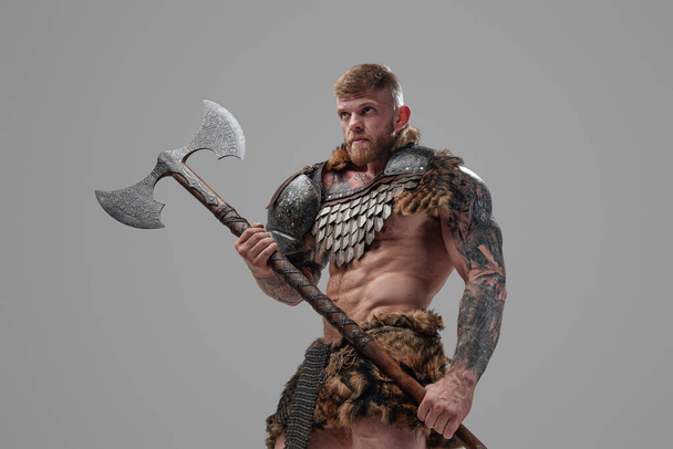Schöner Krieger aus dem Norden mit Axt vor grauem Hintergrund - Foto, Bild