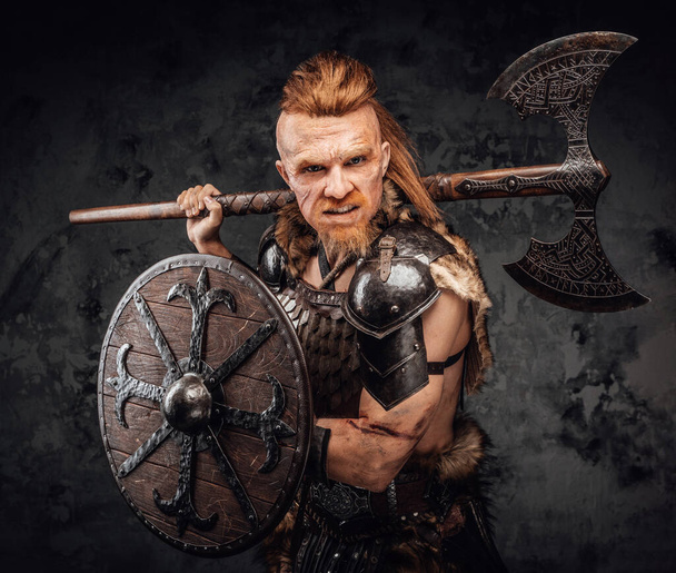 Barbaarse viking met schild en bijl op zijn schouder - Foto, afbeelding