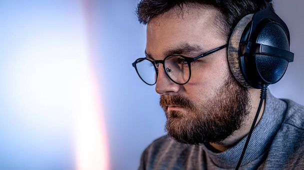 Portrait d'un homme avec lunettes et écouteurs professionnels. - Photo, image