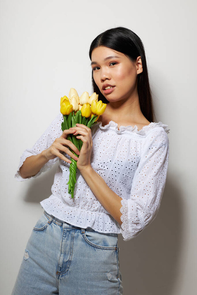 Portrait Asian beautiful young woman romance bouquet of flowers near the face studio model unaltered - 写真・画像