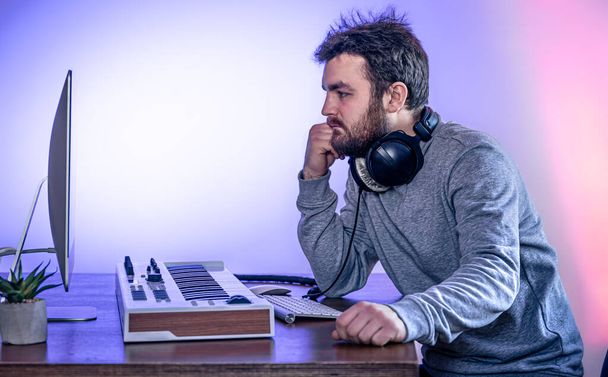 Чоловічий музикант створює музику за допомогою комп'ютера та клавіатури, робоче місце музиканта
. - Фото, зображення