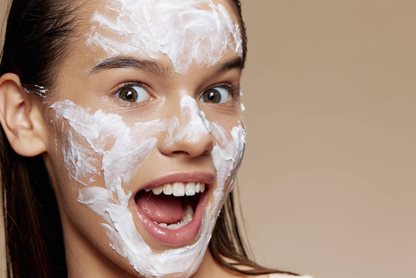 Porträt Frau Gesichtsmaske Creme saubere Haut Gesichtspeeling beige Hintergrund - Foto, Bild