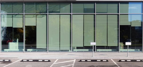 Prázdné parkoviště u nové kancelářské budovy se skleněnými okny - Fotografie, Obrázek
