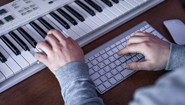 Músico masculino cria música usando computador e teclado, local de trabalho músico. - Foto, Imagem