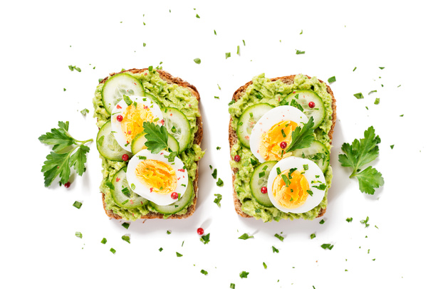Gesundes Frühstückstoast mit Avocado-Smash und gekochtem Ei. isoliert auf weißem Hintergrund, Draufsicht - Foto, Bild
