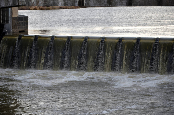 the turbid water during the flood falls from large dams and forms a lot of foam. fish pass is a neutrality for overcoming the height differences of hydroelectric power plants and weirs for fish. - Photo, Image