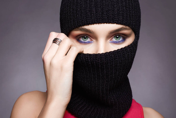 beautiful girl in black balaclava. Trendy Mask on pretty woman. New Hat style - Zdjęcie, obraz