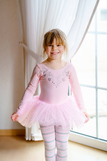Malá školačka sní o tom, že se stane baletkou v růžové sukni. Šťastné zdravé dítě a baletní výchova, gymnastika pro děti. - Fotografie, Obrázek