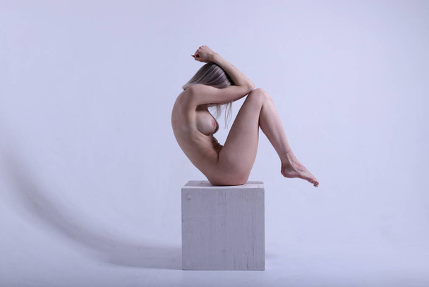 Beautiful stunning young naked woman demonstrating fit body on  gray background.  - Fotoğraf, Görsel