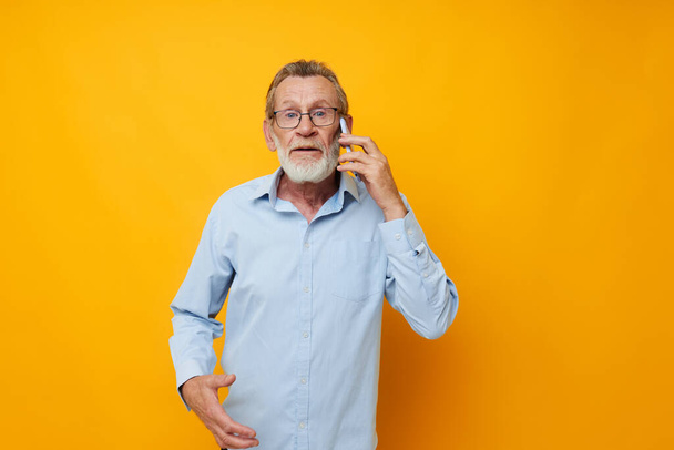 Senior grey-haired man talking on the phone emotions isolated background - Photo, Image