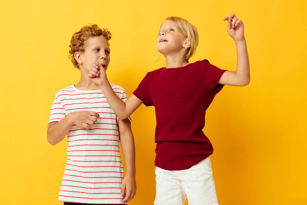 Cute preschool kids standing side by side posing childhood emotions yellow background - Photo, Image