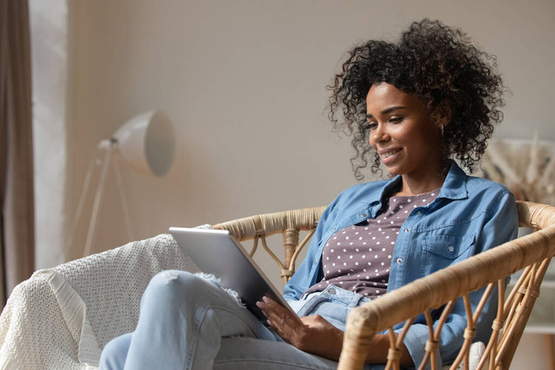 Happy young African American woman using digital computer tablet. - Foto, imagen