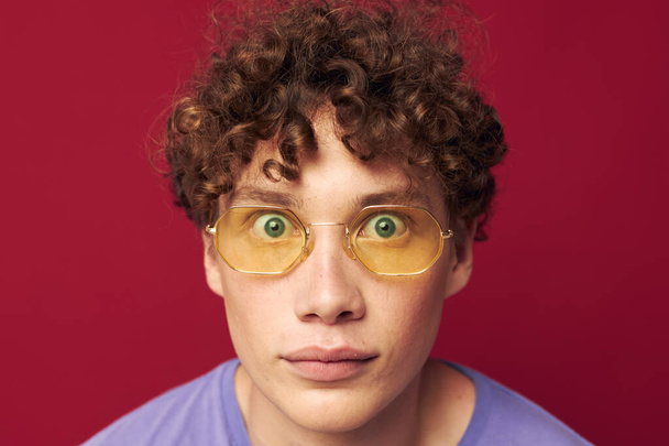 portrait of a young curly man in yellow glasses purple t-shirt emotions Lifestyle - Valokuva, kuva