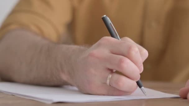 Hände in Großaufnahme von jungem Mann, der auf Papier schreibt - Filmmaterial, Video