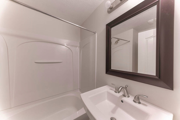 Sisätilojen pieni kylpyhuone kehystetty peili yläpuolella pesuallas laajalle levinnyt ruostumaton hana - Valokuva, kuva
