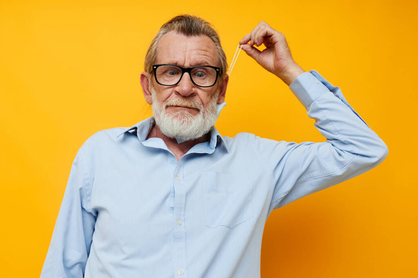 Portrait elderly man with glasses safety medical mask posing yellow background - Foto, afbeelding