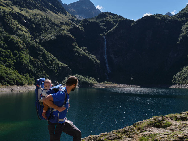 father in baby carrier backpack hiking in mountains. family adventure, outdoor vacation. - Foto, imagen