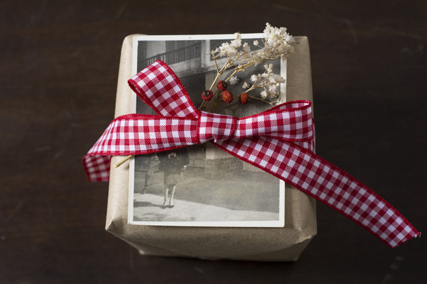 caja de regalo de papel artesanal, fotografía antigua. cinta a cuadros roja
  - Foto, Imagen