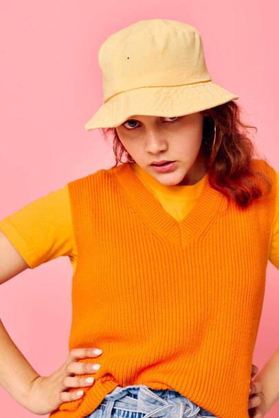portrait of a young woman in an orange sweater in yellow hat hand gesture cropped view unaltered - Fotoğraf, Görsel