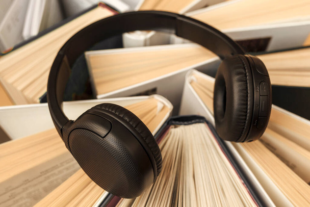 Concept de livre audio. Écouteurs sur livres. Écouteurs pour l'apprentissage en ligne, écoute audio. - Photo, image
