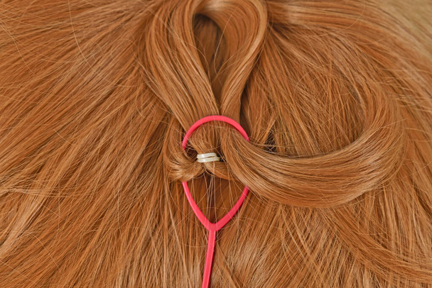 Usage of ponytail pull hair needle styling tool on hair - Zdjęcie, obraz