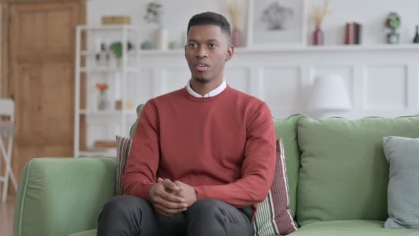 Αφρικανός άνθρωπος βήχει ενώ κάθεται στον καναπέ  - Πλάνα, βίντεο