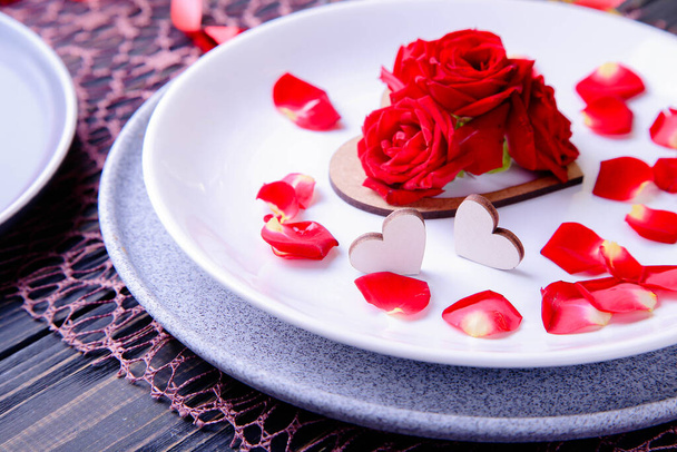Valentin napi tálalás. Gyönyörű asztalterítő vörös rózsákkal - Fotó, kép