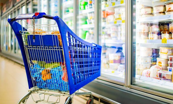 Un carrello della spesa con prodotti alimentari in un supermercato - Foto, immagini