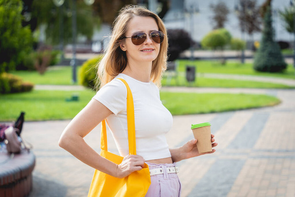 Young beautiful woman with linen eco bag on city background. - Фото, зображення